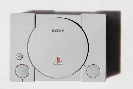 Conceptbeeld van de PlayStation 6 naast een controller met futuristische blauwe verlichting